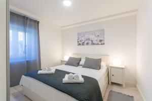 een witte slaapkamer met twee handdoeken op een bed bij Apartments D&D in Dubrovnik