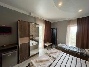 una camera con due letti e uno specchio di Megobroba a Kobuleti