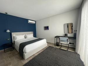 a bedroom with a bed and a blue wall at Misk Villa - Boutique Hotel & Spa in Sidi Bou Saïd