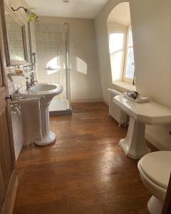 ein Badezimmer mit zwei Waschbecken, einer Dusche und einem WC in der Unterkunft Château de Roberville in Machemont