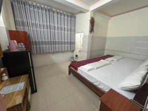 a small room with a bed and a window at HOTEL ANH TUẤN in Ấp Cái Giá