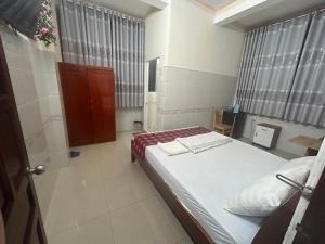 um pequeno quarto com uma cama e uma janela em HOTEL ANH TUẤN em Ấp Cái Giá
