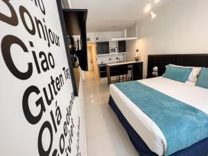 1 dormitorio con 1 cama y cocina en el fondo en Cyan Recoleta Hotel en Buenos Aires