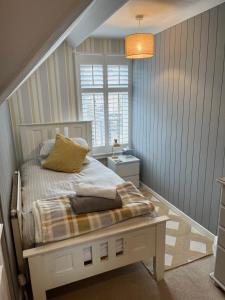 a bedroom with a bed and a window at Camelot Guest House in Falmouth