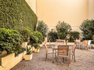 a table and chairs in a courtyard with plants at Cyan Recoleta Hotel in Buenos Aires