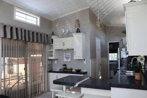 uma cozinha com armários brancos e um balcão preto em Tiny Home in Melbourne Beach em Melbourne Beach