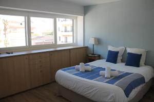 a bedroom with a large bed with blue and white pillows at Duplex de la Baie de st Tropez in Sainte-Maxime