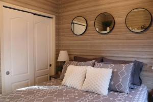 una camera da letto con un letto con tre specchi sul muro di Tiny Home in Melbourne Beach a Melbourne Beach