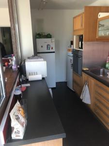 eine Küche mit einer schwarzen Arbeitsplatte und einem Kühlschrank in der Unterkunft Appartement idéal JO in Maisons-Laffitte