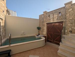 a bathroom with a bath tub next to a building at Casa Leone, whole house with private pool! in Atsipopoulo