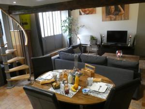 een woonkamer met een tafel en een bank bij La Closerie DAUVILLIERS in Roinville