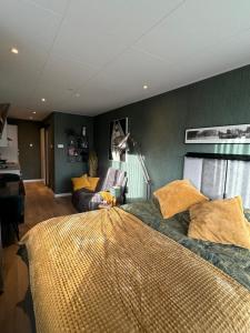 Un dormitorio con una cama grande y un sofá. en De Gouwe Stek, en Landsmeer