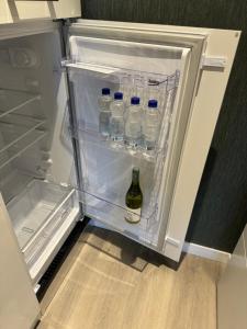 una nevera abierta con botellas de agua. en De Gouwe Stek, en Landsmeer