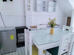 a white table and chairs with a vase of flowers on it at Suite Jacinto in Villahermosa +6 photos