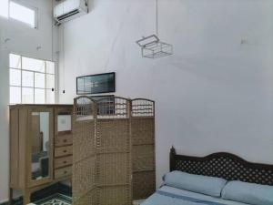 Habitación con cama y TV en la pared. en Suite Jacinto en Villahermosa