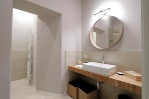 een badkamer met een wastafel en een spiegel bij [Soggiorno di Lusso] nel Centro Storico di Modena in Modena