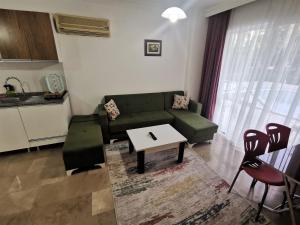 sala de estar con sofá verde y mesa en Maya Apart Antalya en Antalya