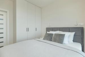 Łóżko lub łóżka w pokoju w obiekcie HS Apartamenty Hevenia Sun widok na morze