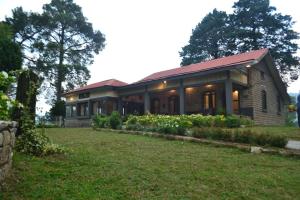 uma casa de tijolos com um relvado em frente em Batrasi Dak Bungalow 