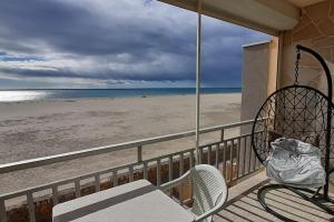 Un balcón con mesa y sillas en la playa. en La Plage, clim et wifi, en Port-la-Nouvelle