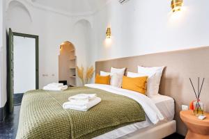 a bedroom with a large bed with towels on it at Riad Dar Nakous in Marrakesh