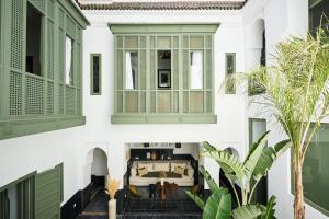 a room with green shutters on the windows of a house at Riad Dar Nakous in Marrakesh