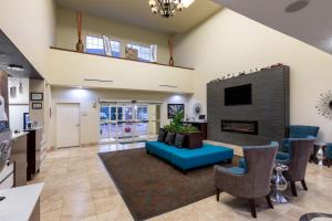 a living room with a blue couch and a fireplace at La Quinta by Wyndham Houston New Caney in New Caney