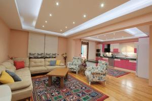 ein Wohnzimmer mit einem Sofa und Stühlen sowie eine Küche in der Unterkunft Lüks Bahçeli Özel Havuzlu Villa in Fethiye