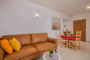 sala de estar con sofá marrón y mesa en Apartments Kvarner, en Malinska