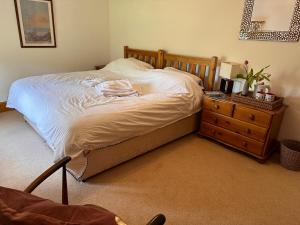 a bedroom with a bed with a wooden frame and a dresser at Lara's House in Balderstone
