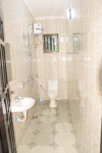 La salle de bains est pourvue de toilettes et d'un lavabo. dans l'établissement Two Bedrooms Apartment Moshi, à Bunju