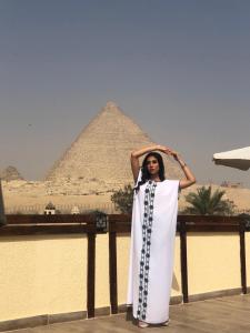 Una donna in piedi di fronte alle piramidi di Pyramids Era View a Il Cairo