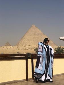 a man is standing in front of the pyramids at Pyramids Era View in Cairo