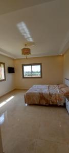1 dormitorio con 2 camas y TV. en Dar HAKIM piscine privée en Marrakech
