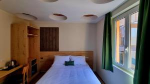 a bedroom with a white bed with a window at Botanique Hotel Vergani in Fara Gera dʼAdda