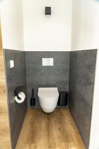 a bathroom with a white toilet in the corner at Glashaus mit 3 Gästezimmer in Mettingen