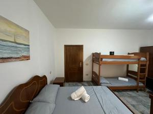 a bedroom with a bed and two bunk beds at Hotel Adriatik Shengjin in Shëngjin