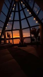 ein Zimmer mit einem Fenster mit Blick auf den Sonnenuntergang im Hintergrund in der Unterkunft WIÑAY TITICACA LODGE in Puno
