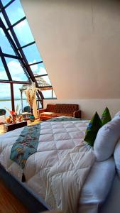 a large bed in a room with a large window at WIÑAY TITICACA LODGE in Puno