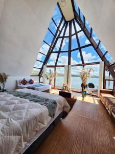 Un dormitorio con una gran ventana de cristal y una cama en WIÑAY TITICACA LODGE, en Puno