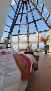 una camera da letto con una grande stanza con una grande finestra di WIÑAY TITICACA LODGE a Puno