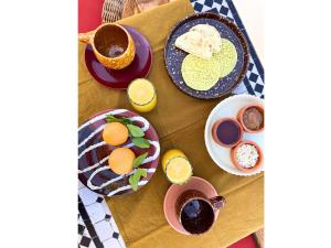 a table with plates of eggs and cups of coffee at Riad Dar Nakous in Marrakesh