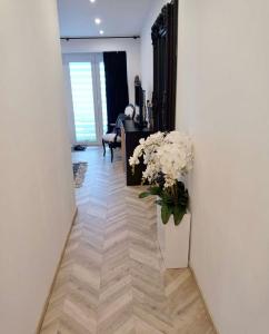 a hallway with a vase of flowers on the floor at Apartament u Danuty in Białystok