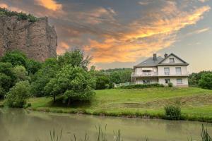 a house on top of a hill next to a river at Dormez au cœur d'un volcan, dans une nature unique in Chambon-sur-Lac