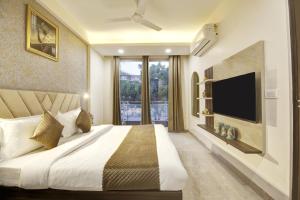 a bedroom with a large bed with a flat screen tv at Limewood Stay Golf Course Road in Gurgaon