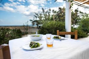 a table with two plates of food and a drink at Sea Breeze Beach House in Skiros