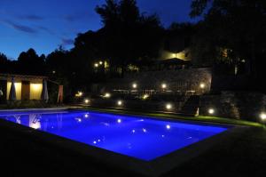 a swimming pool with blue water at night at Relais Victoria B&B in San Macario In Piano