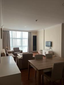 a living room with a table and chairs and a television at Blue Horizon Suites in Manama