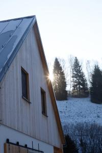 un granero con el sol brillando en un campo cubierto de nieve en romantic cabin Methuya en Teplice nad Metují