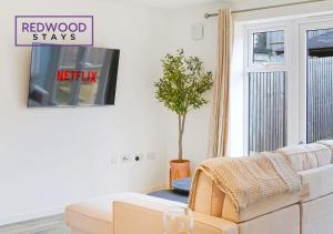 a living room with a couch and a tv at BRAND NEW! 3 Bed 2 Bath House, NEAR HOSPITAL, With FREE x2 Parking & Wi-Fi By REDWOOD STAYS in Basingstoke